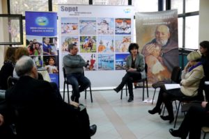Wiceprezydent Sopotu siedzi naprzeciwko uczestników spotkania i rozmawia z zaproszonym Syryjczykiem Samer Samaan