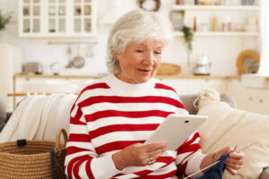 Starsza kobieta patrzy w tablet