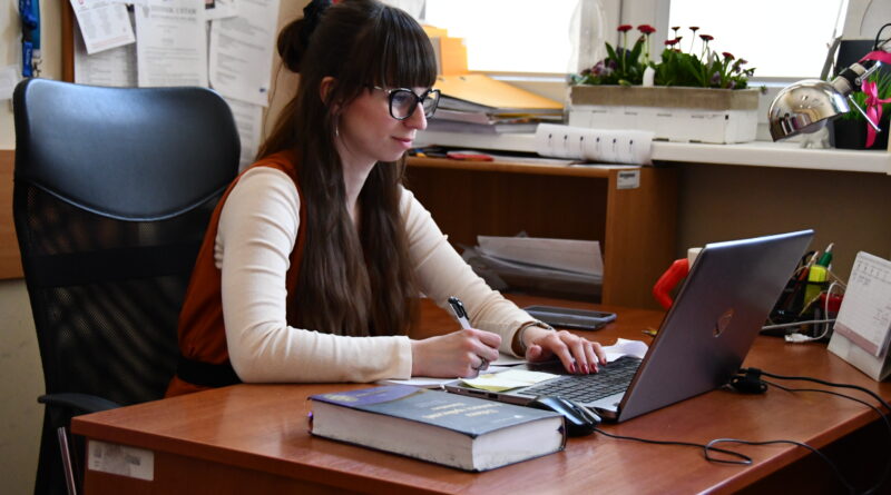 kobieta siedzi przy biurku przed laptopem