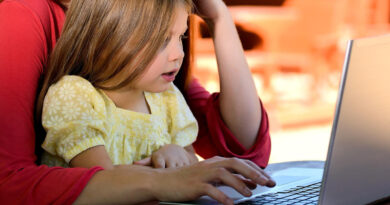 kobieta z dzieckiem siedzi przed laptopem