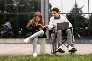młody mężczyzna na wózku inwalidzkim rozmawia z dziewczynką