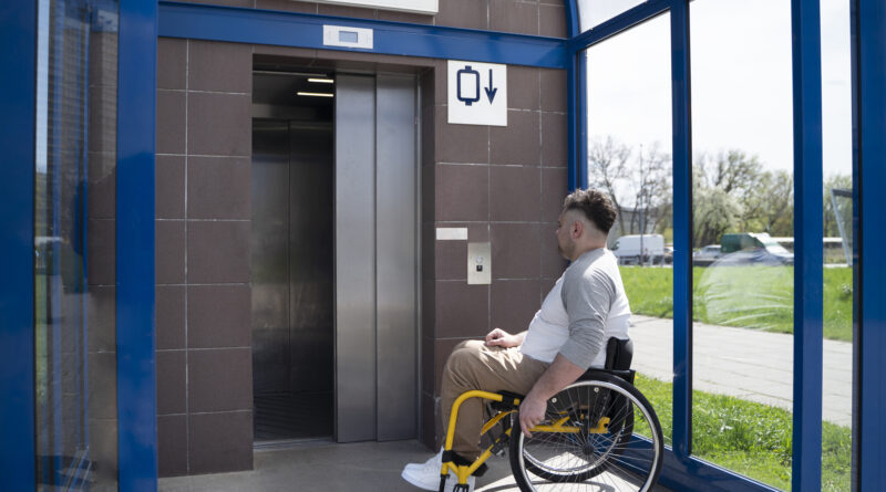 mężczyzna na wózku czeka na windę