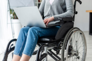 kobieta na wózku inwalidzkim pracuje na laptopie