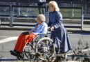 kobieta pcha wózek z niepełnosprawną starszą kobietą