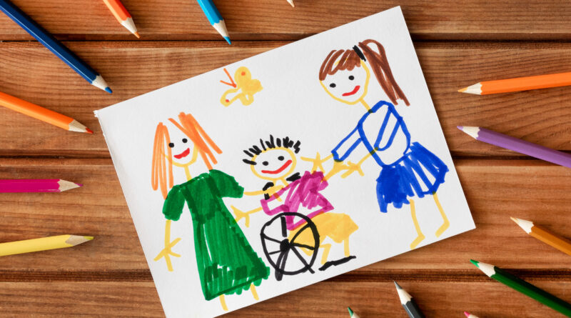 na rysunku znajduje się dziecko na wózku inwalidzkim, obok stoją dwie dziewczynki