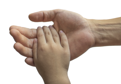dłoń osoby dorosłej trzyma rękę dziecka