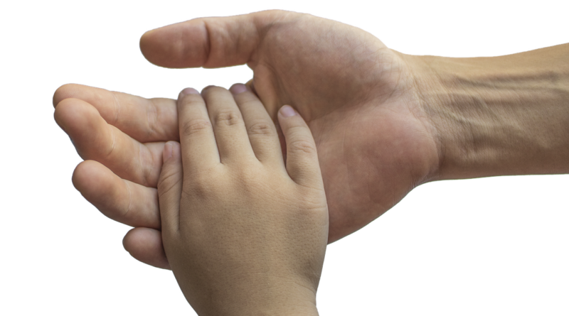 dłoń osoby dorosłej trzyma rękę dziecka