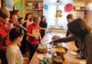 grupa osób dzieci i dorosłych stoi przy stole z tortem