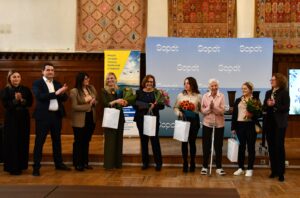 osoby nagrodzone stoją na podium