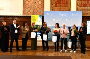 osoby nagrodzone stoją na podium