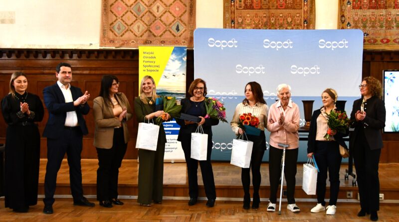 osoby nagrodzone stoją na podium